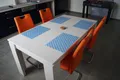 Esstisch mit orangen Stühlen in der Appartementküche