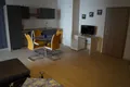 Appartement mit Küchenzeile, Essgruppe mit gelben Stühlen und Fernseher
