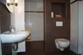 Bad mit Waschbecken, WC und braunen Fliesen