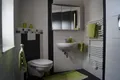 Bad mit Waschbecken, WC und grünen Handtüchern