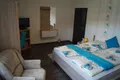 Doppelzimmer mit türkiser Bettwäsche, Sessel und Fernseher