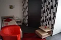 Einzelzimmer mit rotem Sessel, Couchtisch und gemusterter Wand