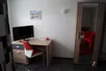 Schreibtisch mit Fernseher und Spiegelschrank im Einzelzimmer