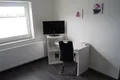 Weißer Arbeitsplatz mit Fernseher unter dem Fenster