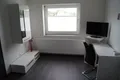 Helles Zimmer mit Schreibtisch, Fernseher und Fenster